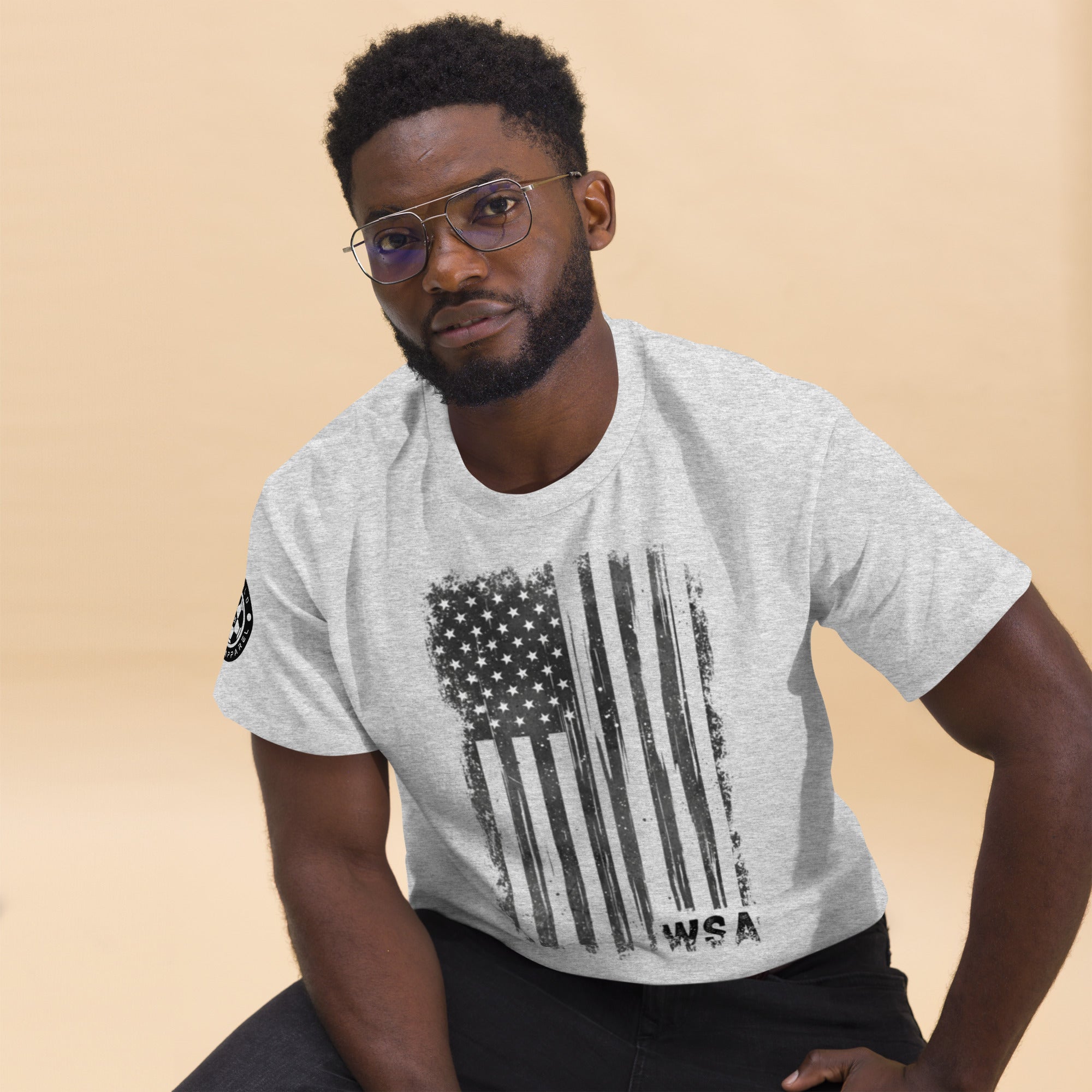 Man wearing a gray t-shirt with an American flag design on a beige background