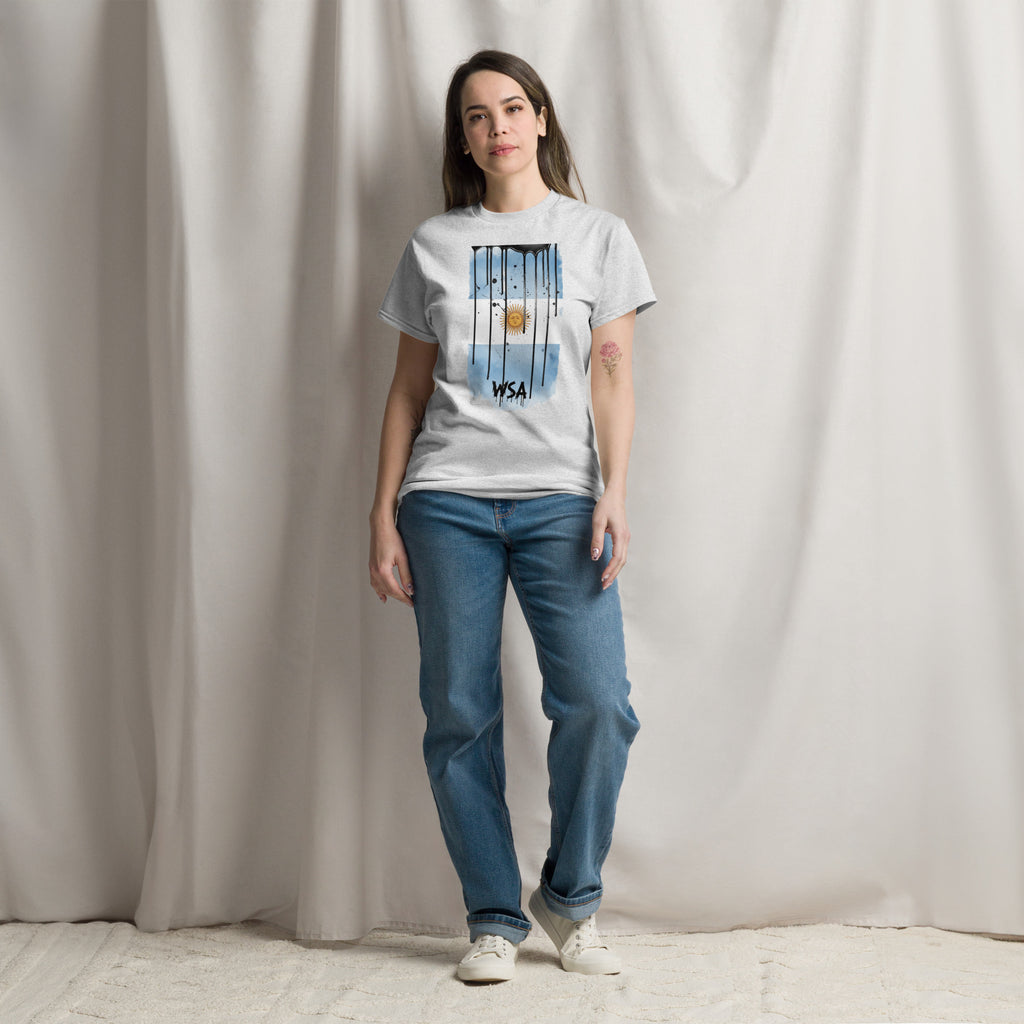 Person wearing a white t-shirt with a graphic design and blue jeans against a plain background