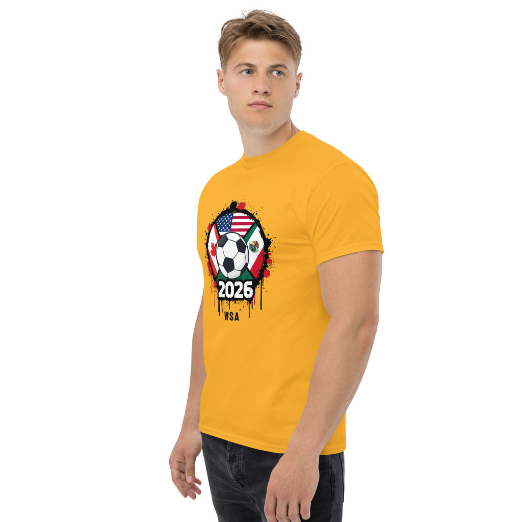 Man wearing a yellow t-shirt with a soccer ball design featuring the USA, Mexico, and Canada flags and the year 2026.