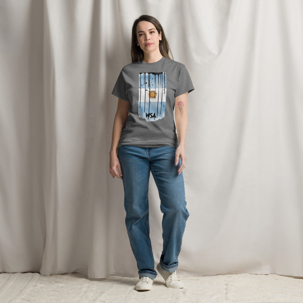 Person wearing a gray t-shirt with a graphic design and blue jeans against a plain background