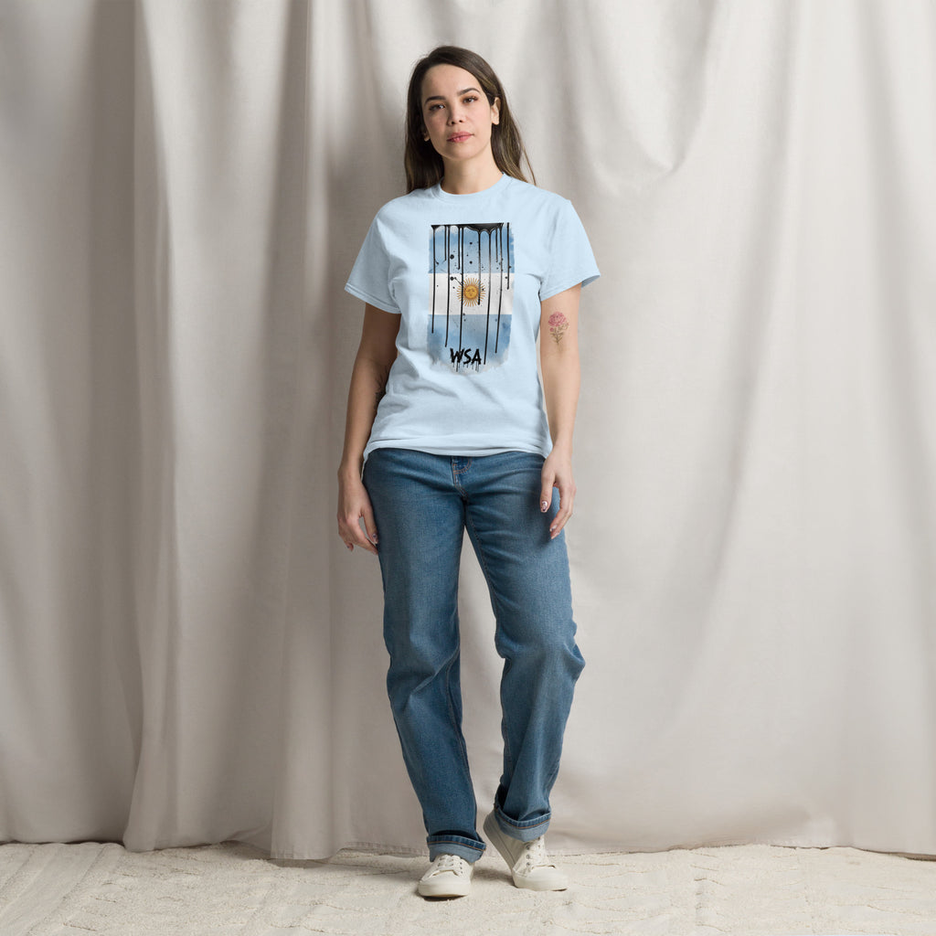 Woman wearing a light blue t-shirt and jeans standing against a plain background