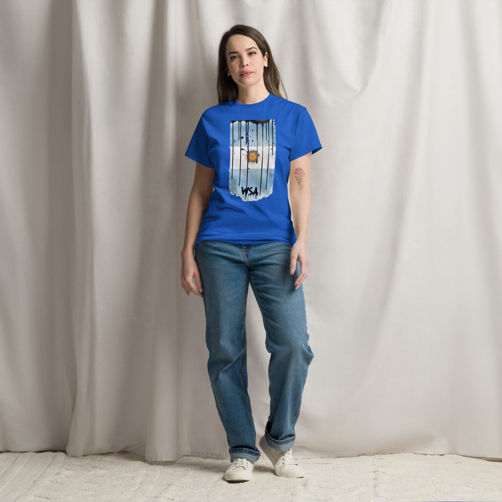 Person wearing a blue t-shirt with a graphic design and jeans standing against a plain background