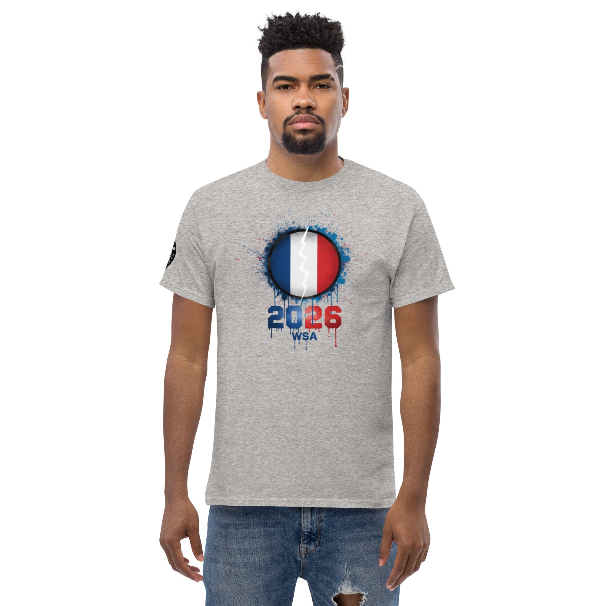 Man wearing a gray t-shirt with a design featuring the number 2026 and text on a white background