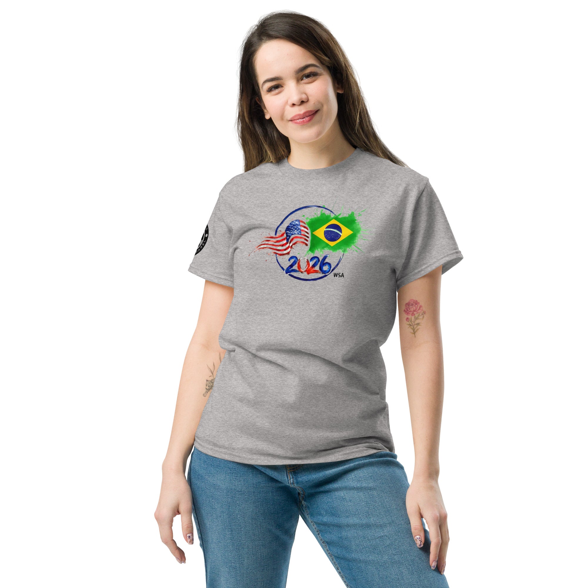 Woman wearing a gray t-shirt with a design featuring the American and Brazilian flags, standing against a white background.