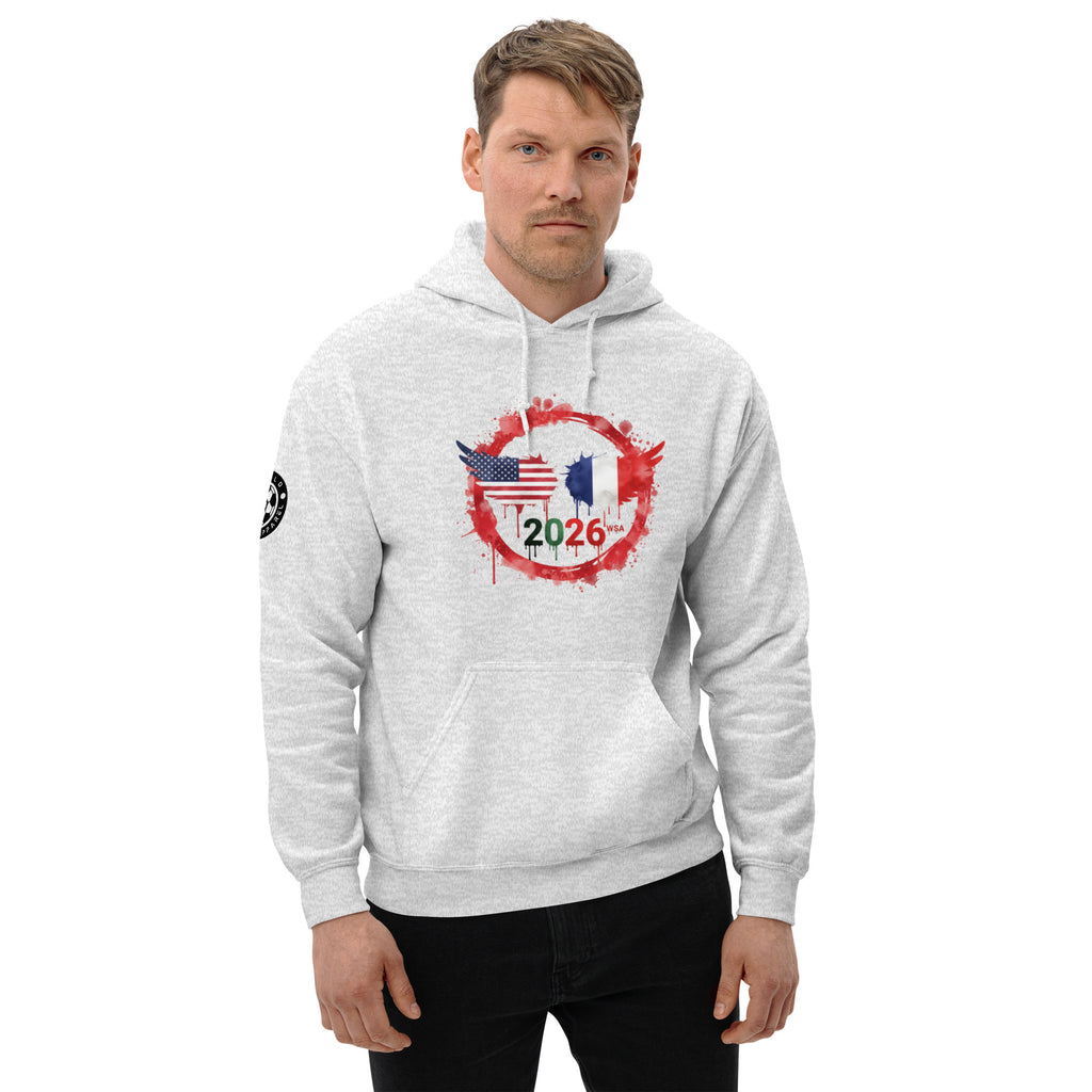 Man wearing a gray hoodie with a design featuring the American and French flags and the number 2026 on a white background.