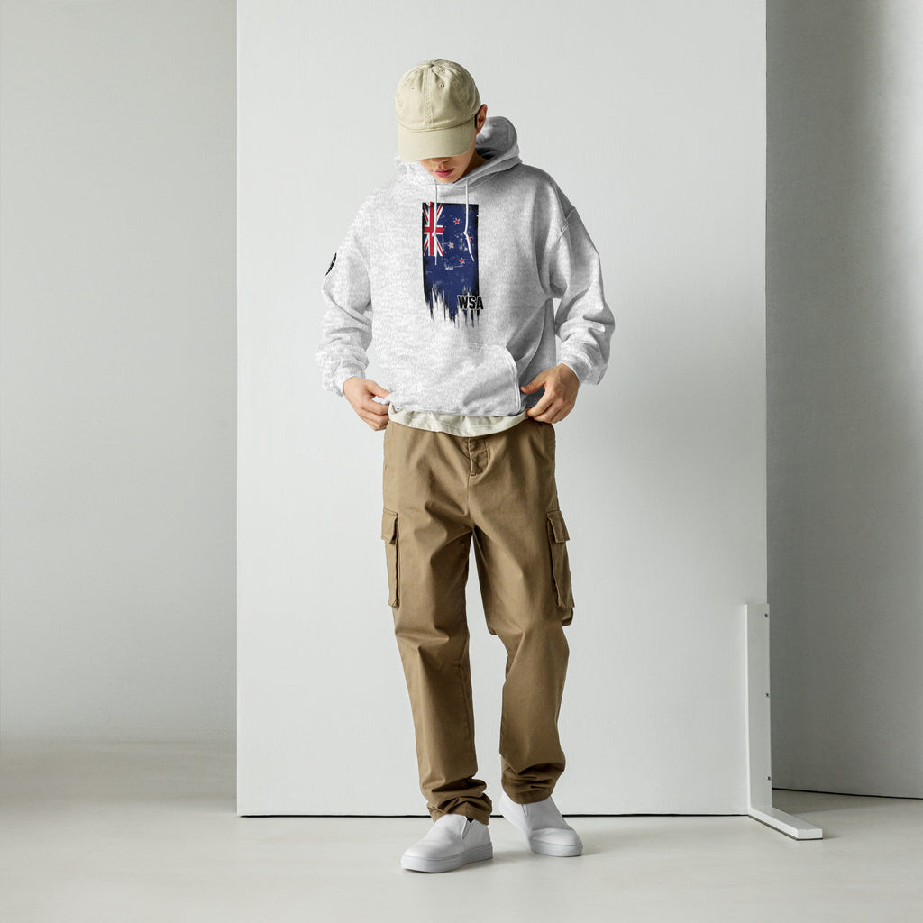 Person wearing a white hoodie with a graphic design, beige cap, and brown cargo pants against a plain background