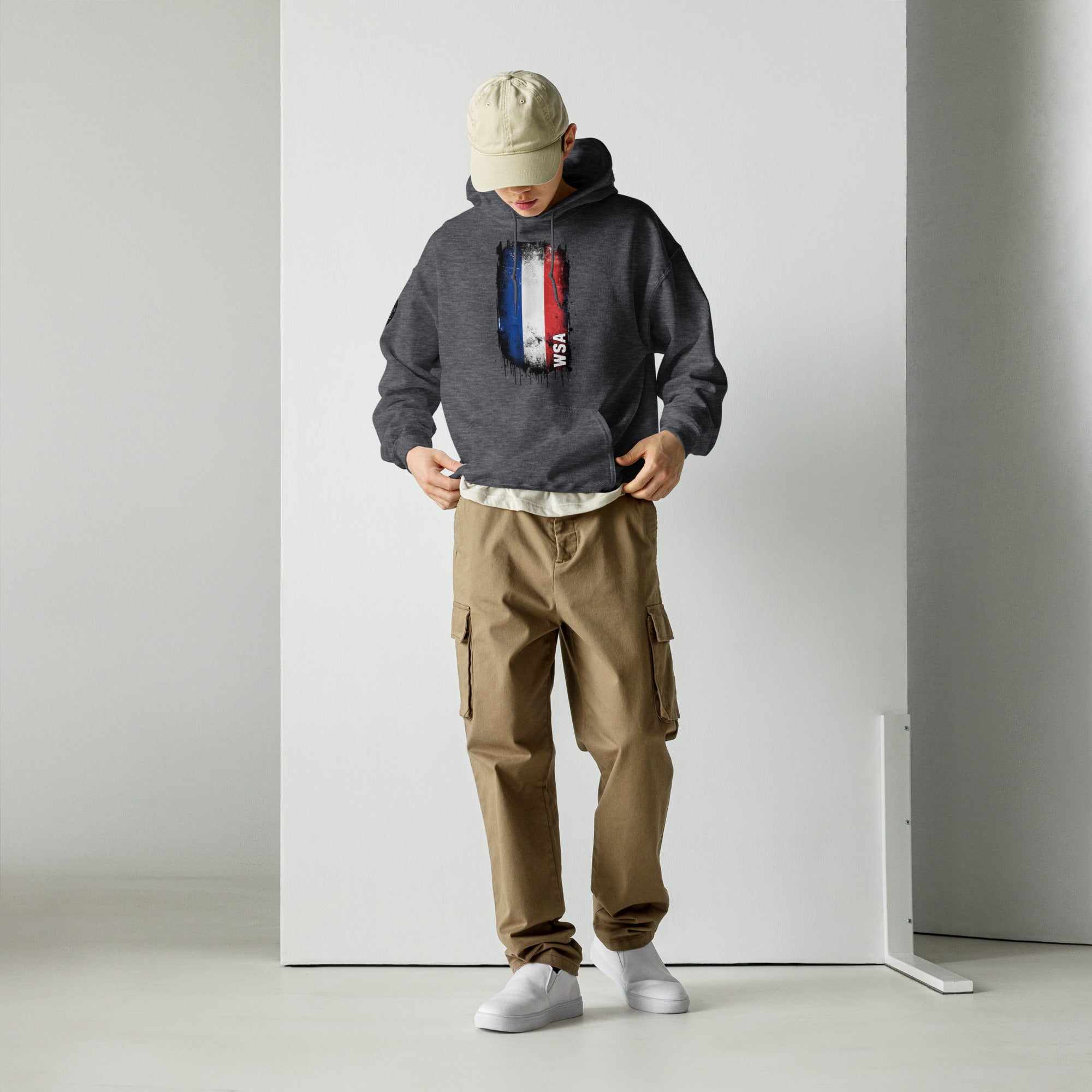 Person wearing a hoodie with text and cargo pants in a minimalistic setting