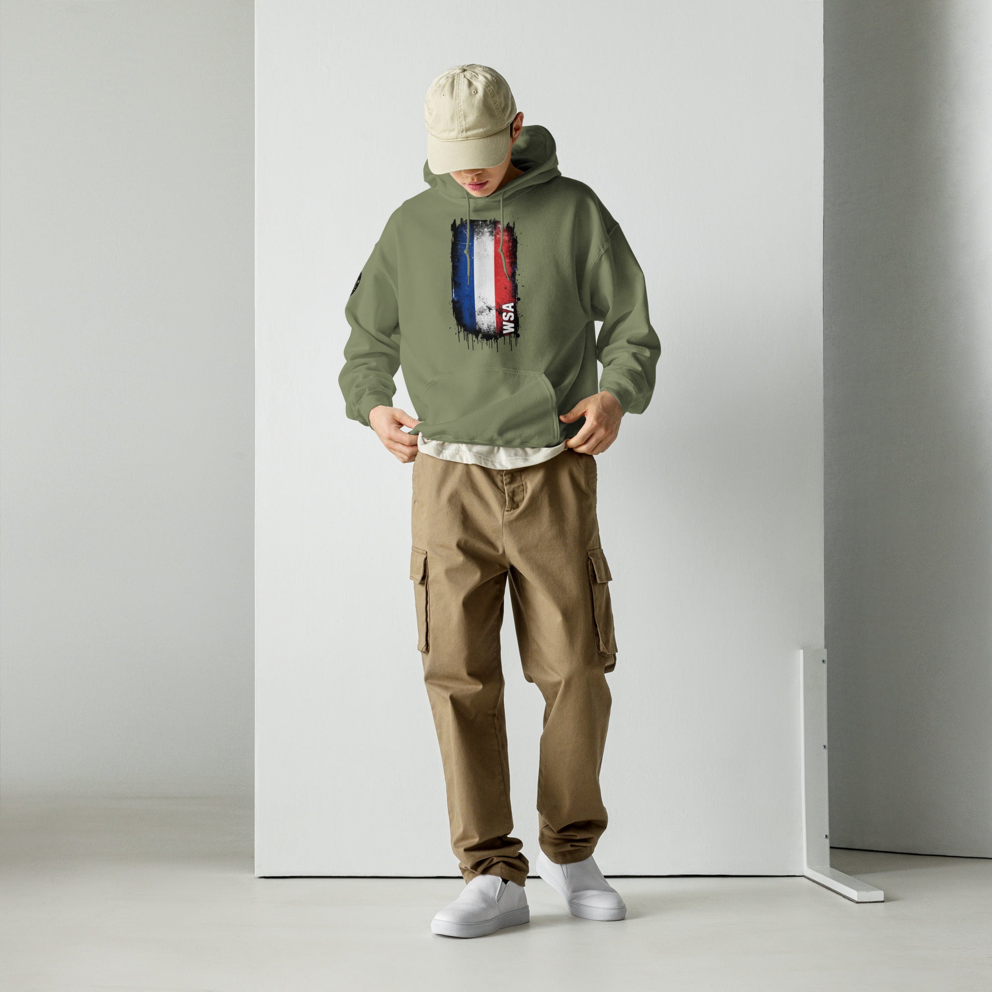 Person wearing a green hoodie with a graphic design and brown cargo pants against a white background