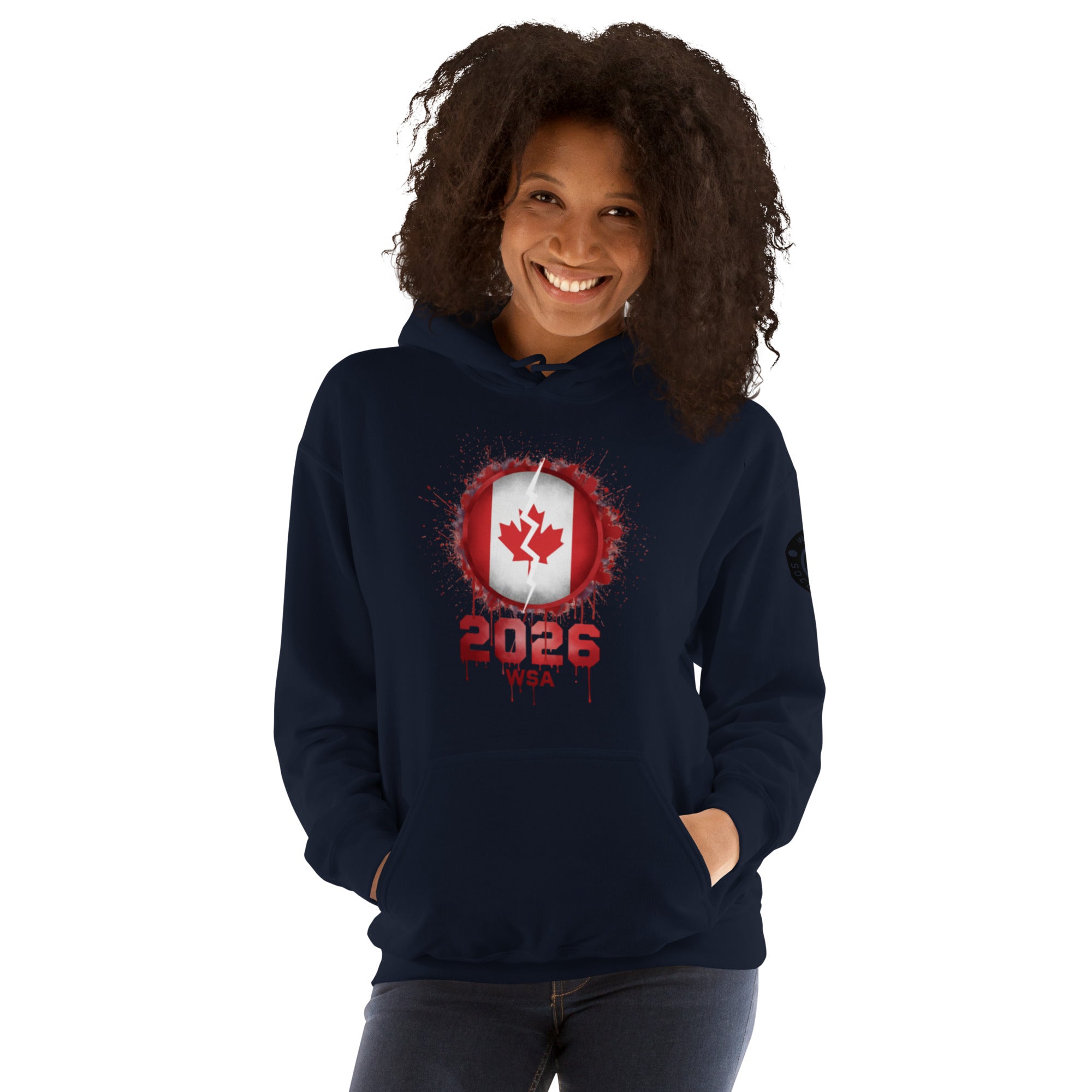 Person wearing a navy hoodie with a red and white design featuring the number 2026 and a maple leaf on a white background.