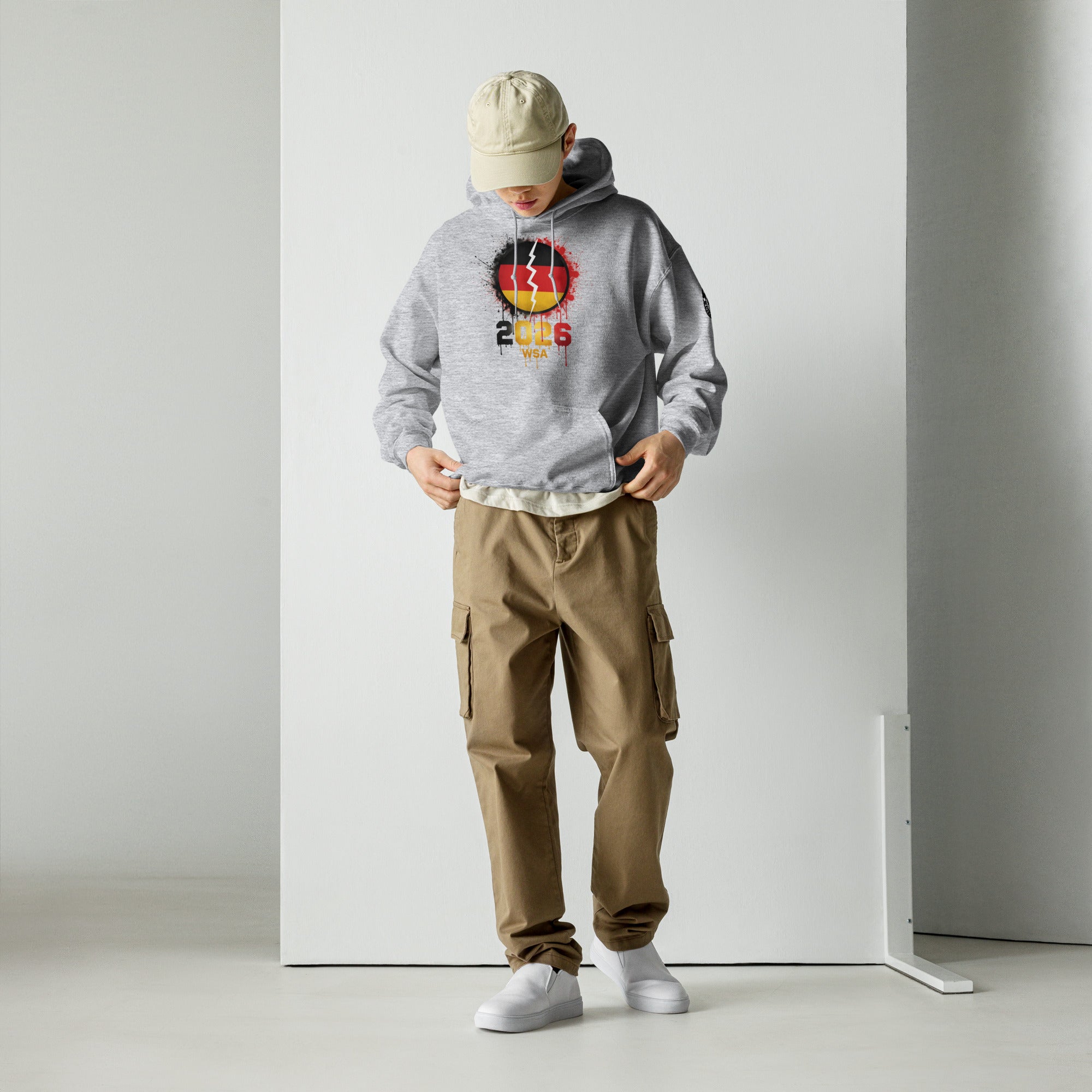 Person wearing a gray hoodie with a logo and brown cargo pants against a white background