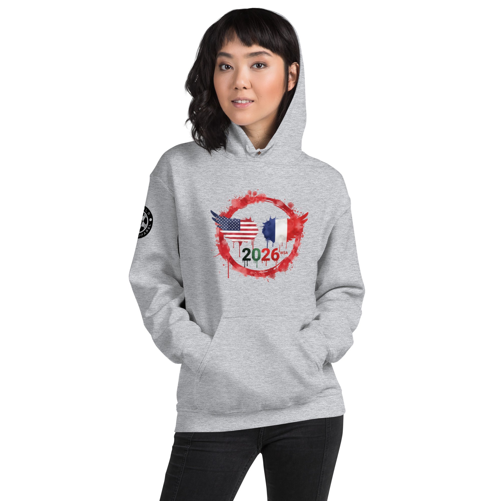 Person wearing a gray hoodie with a design of an American flag, French flag, and number 2026 on a white background