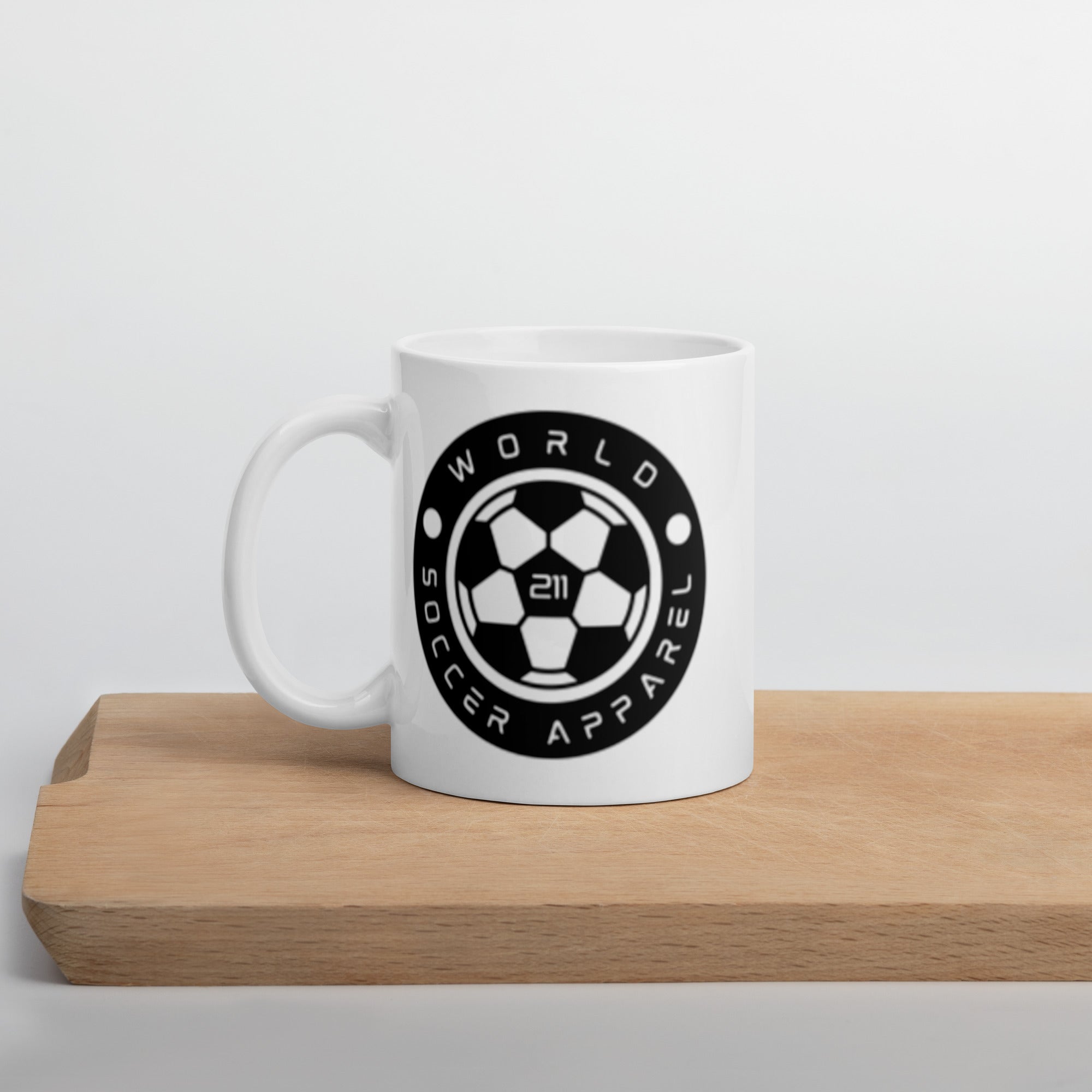 White mug with black logo on a wooden surface