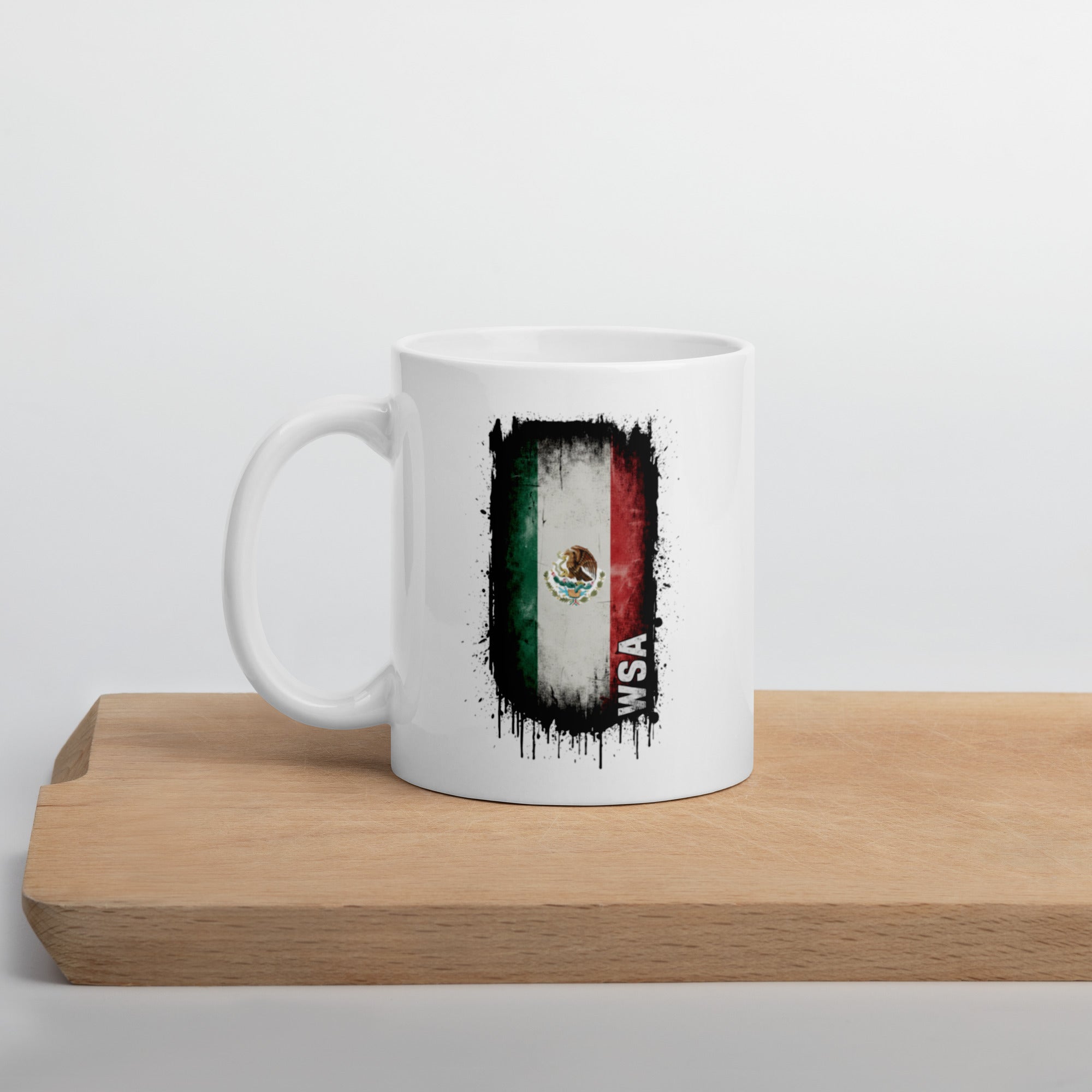 White mug with Mexican flag design on a wooden surface