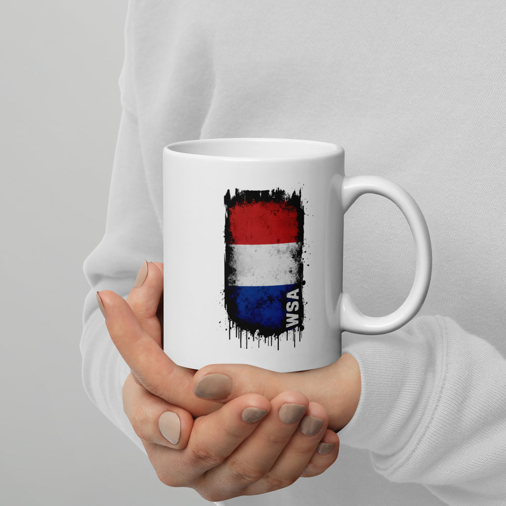 Person holding a white mug with a colorful design and text on a gray background