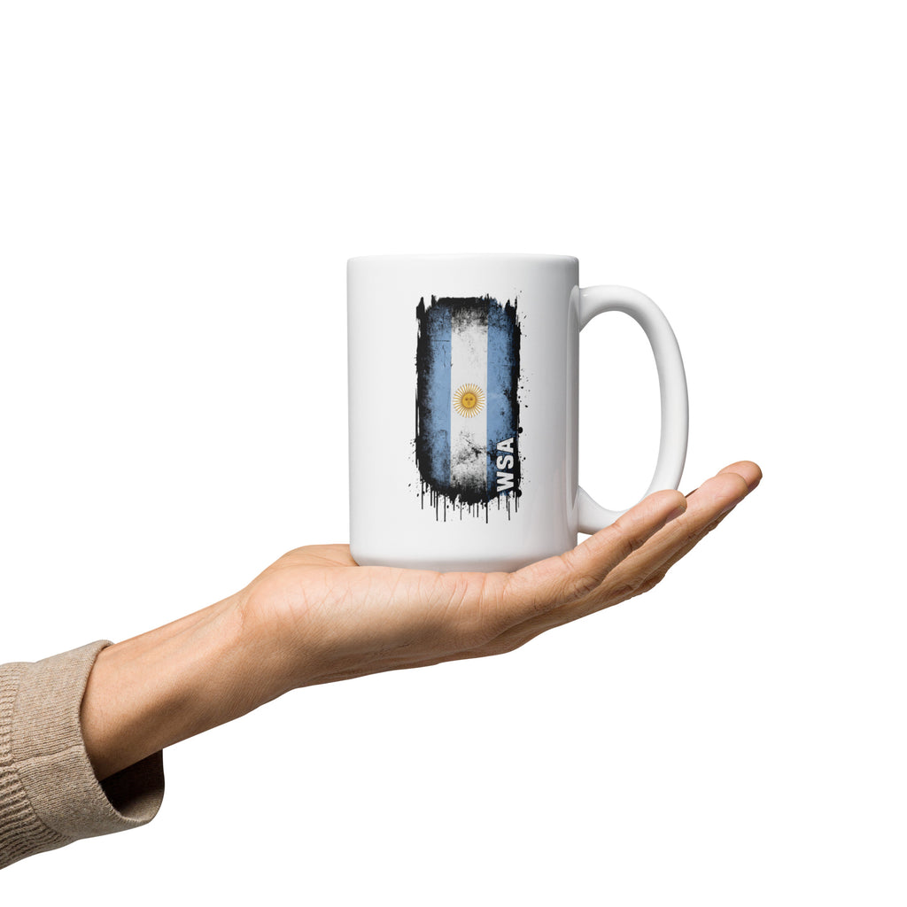 White mug with Argentina flag design held in a hand on a white background