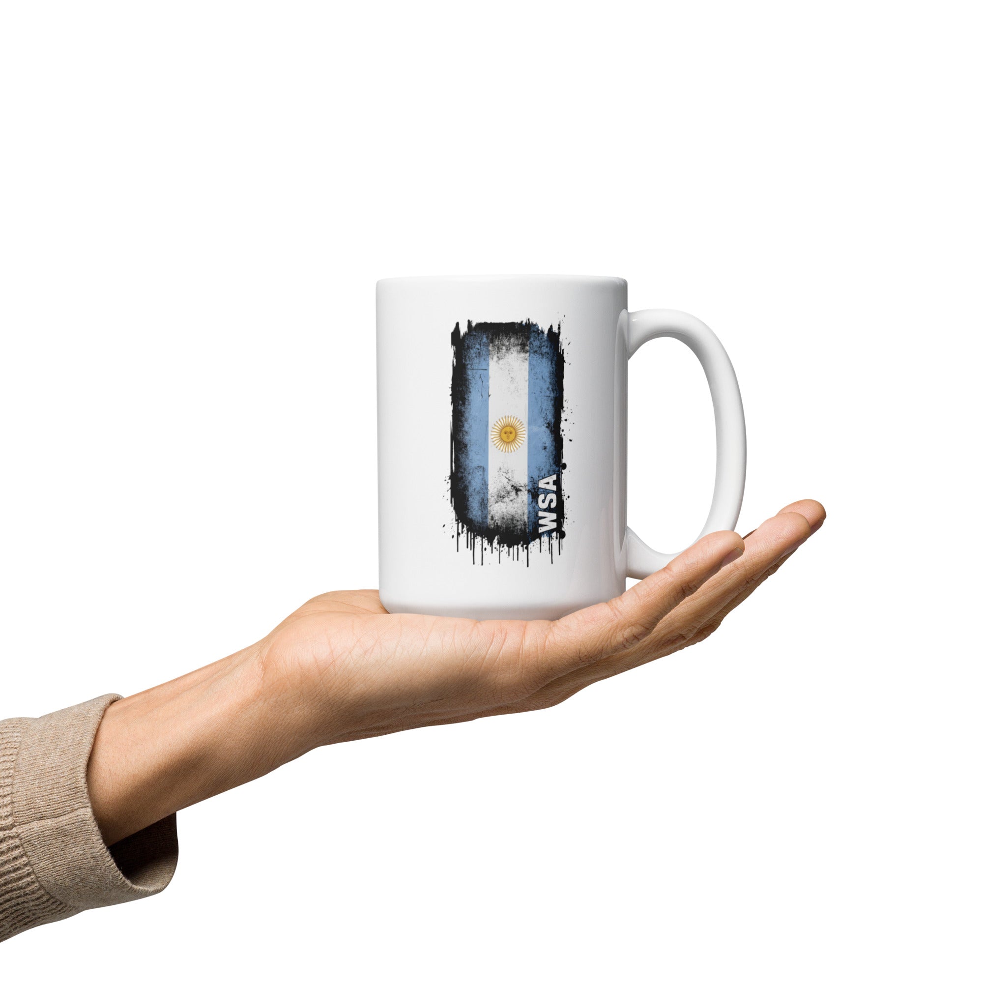 White mug with Argentina flag design held in a hand on a white background