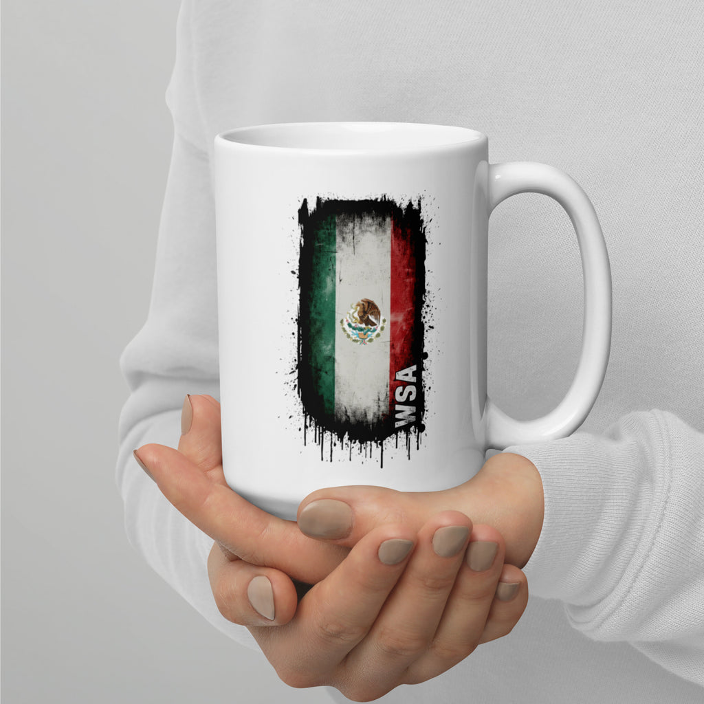White mug with Mexican flag design held by a person against a gray background