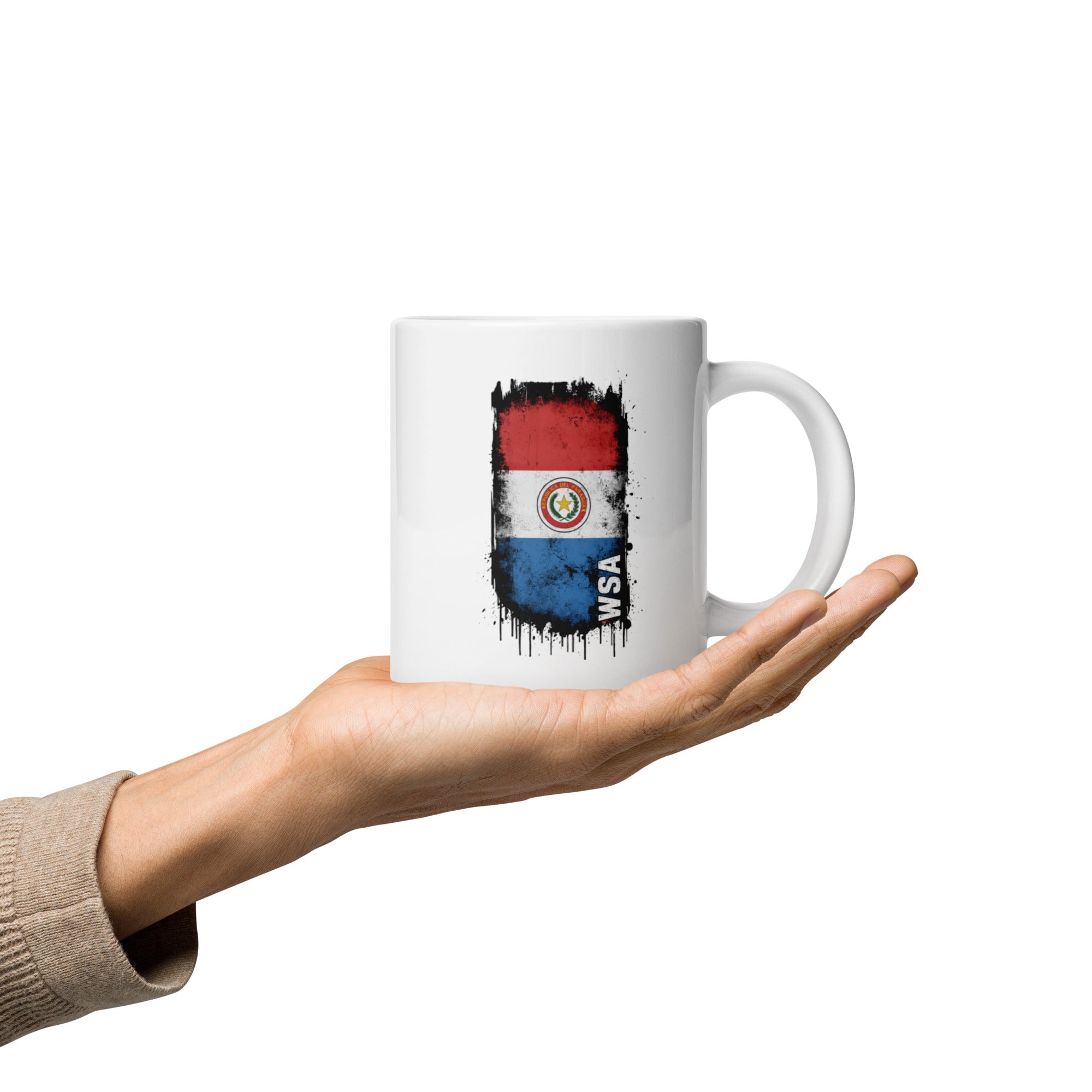 White mug with a flag design held by a hand on a white background