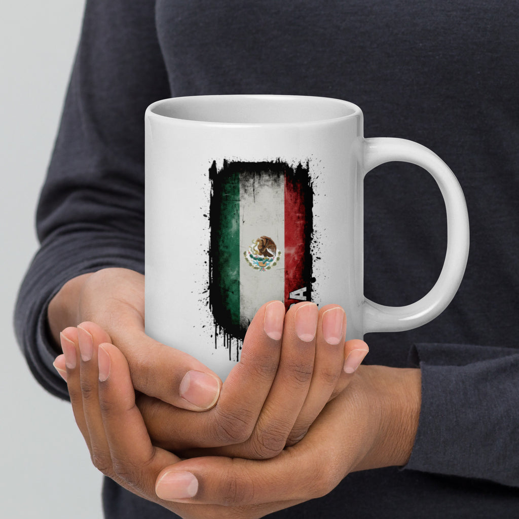 Person holding a white mug with a colorful design on a plain background