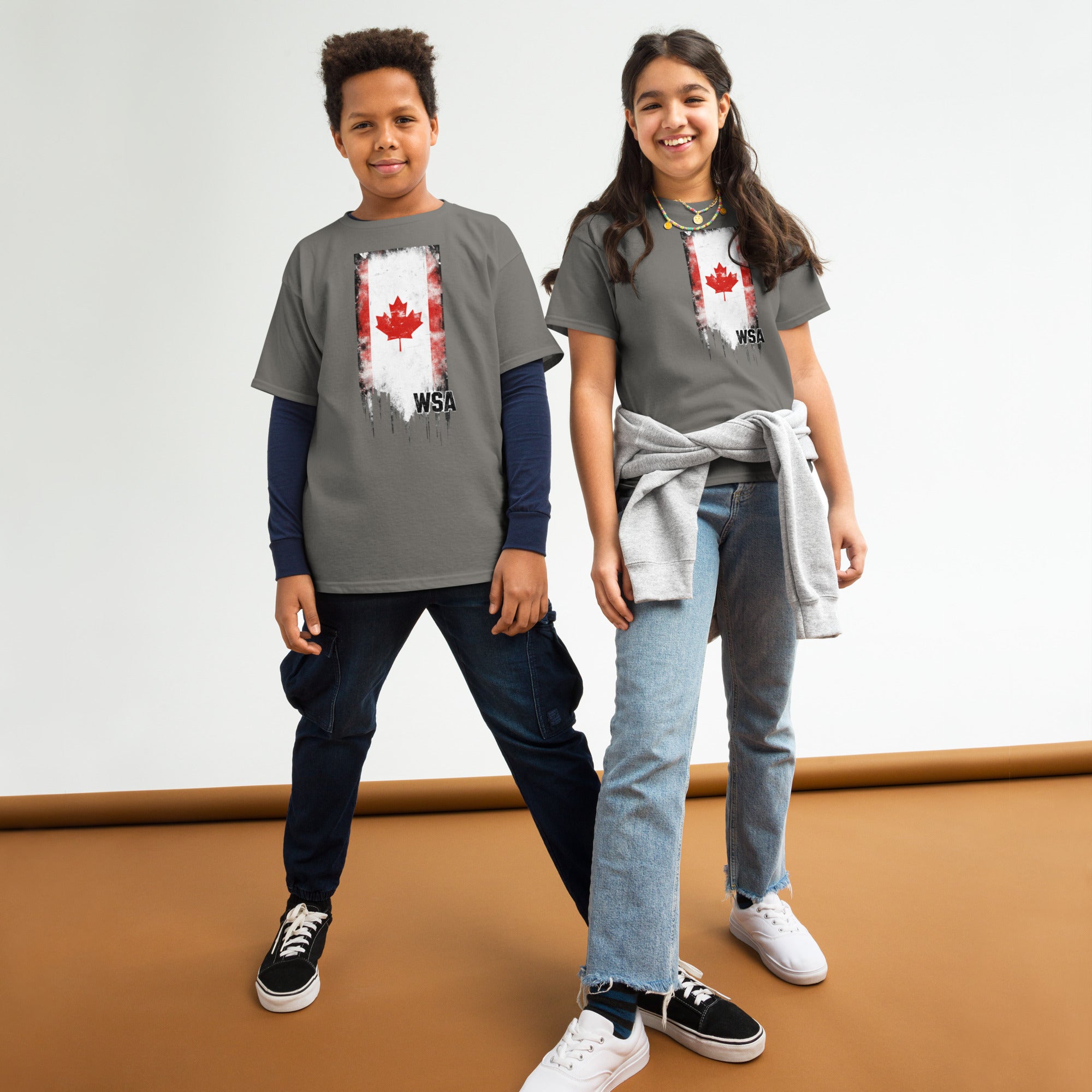 Two children wearing gray t-shirts with a design on a white background