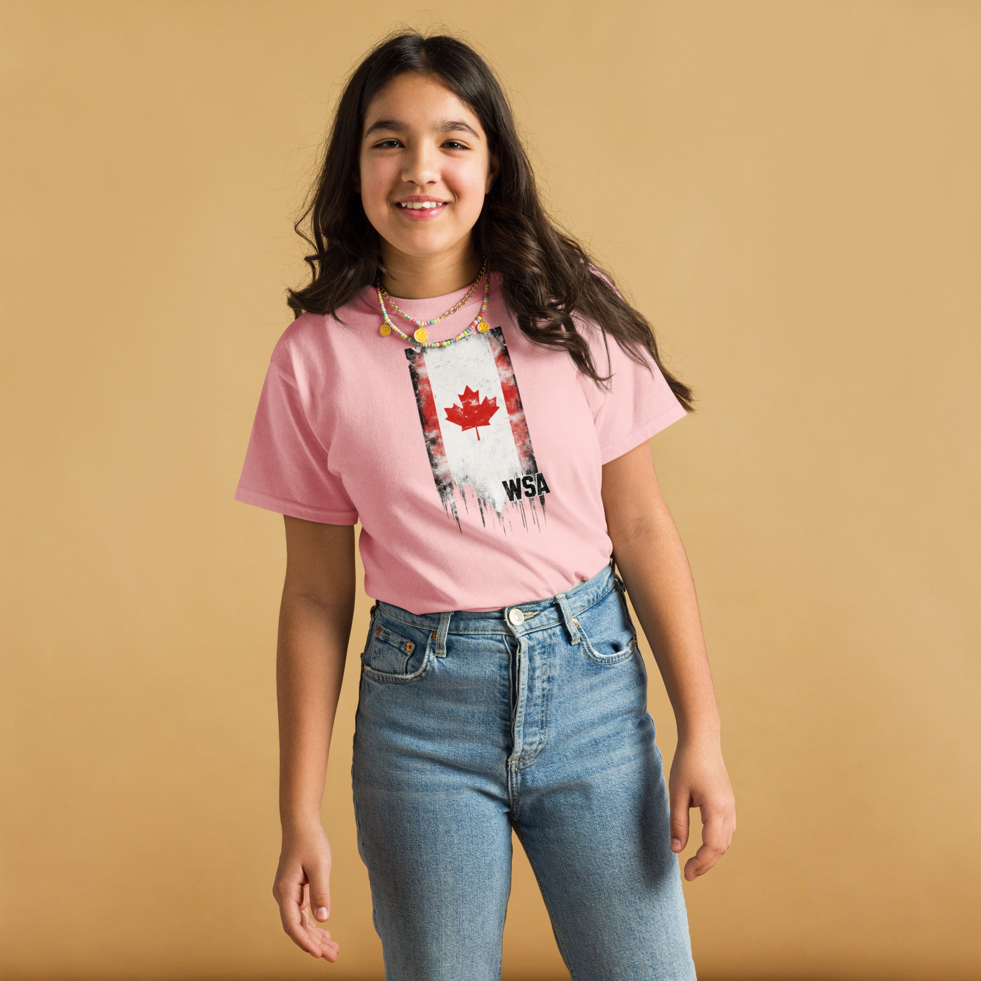 Person wearing a pink t-shirt with a graphic design on a beige background