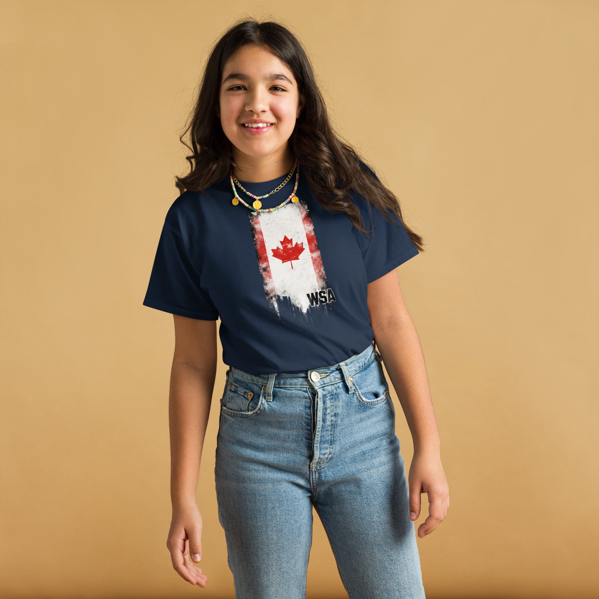 Person wearing a navy blue t-shirt with a red maple leaf design on a beige background