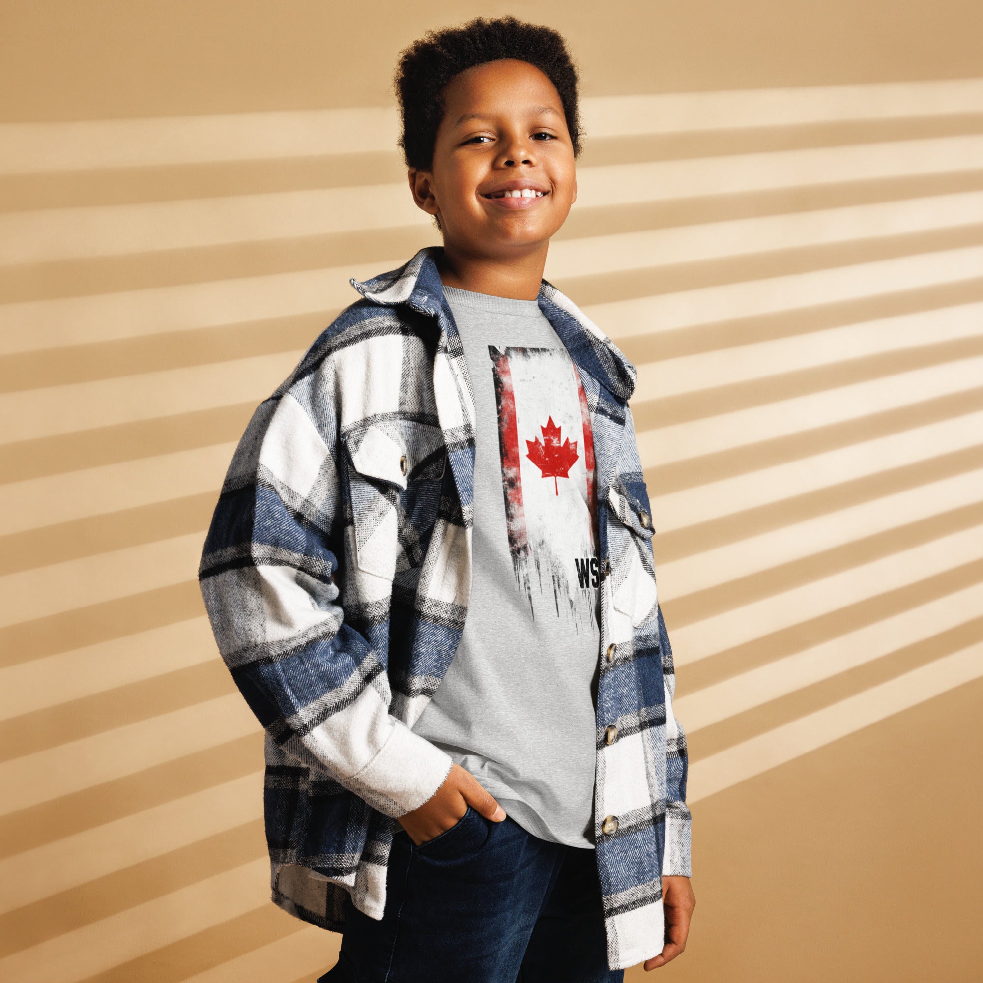 Child wearing a plaid shirt over a graphic t-shirt with a striped background