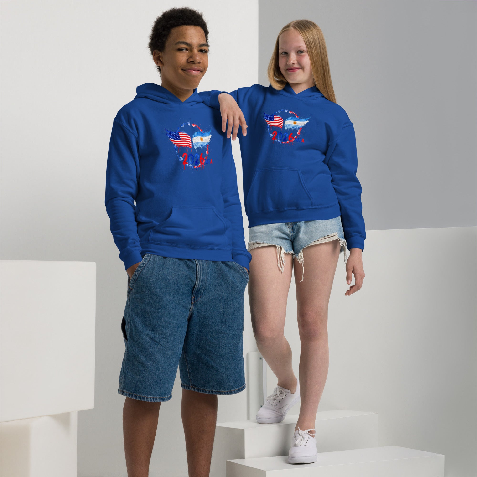 Two children wearing blue hoodies with a graphic design on a white background