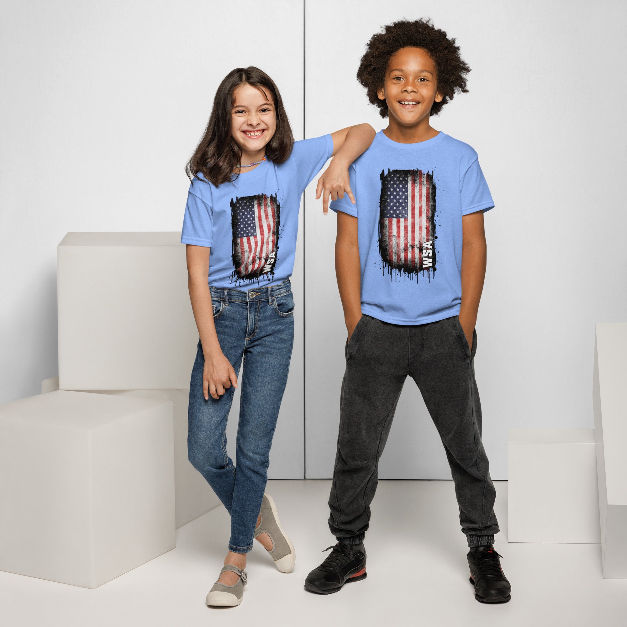 Two children wearing blue t-shirts with an American flag design on a white background