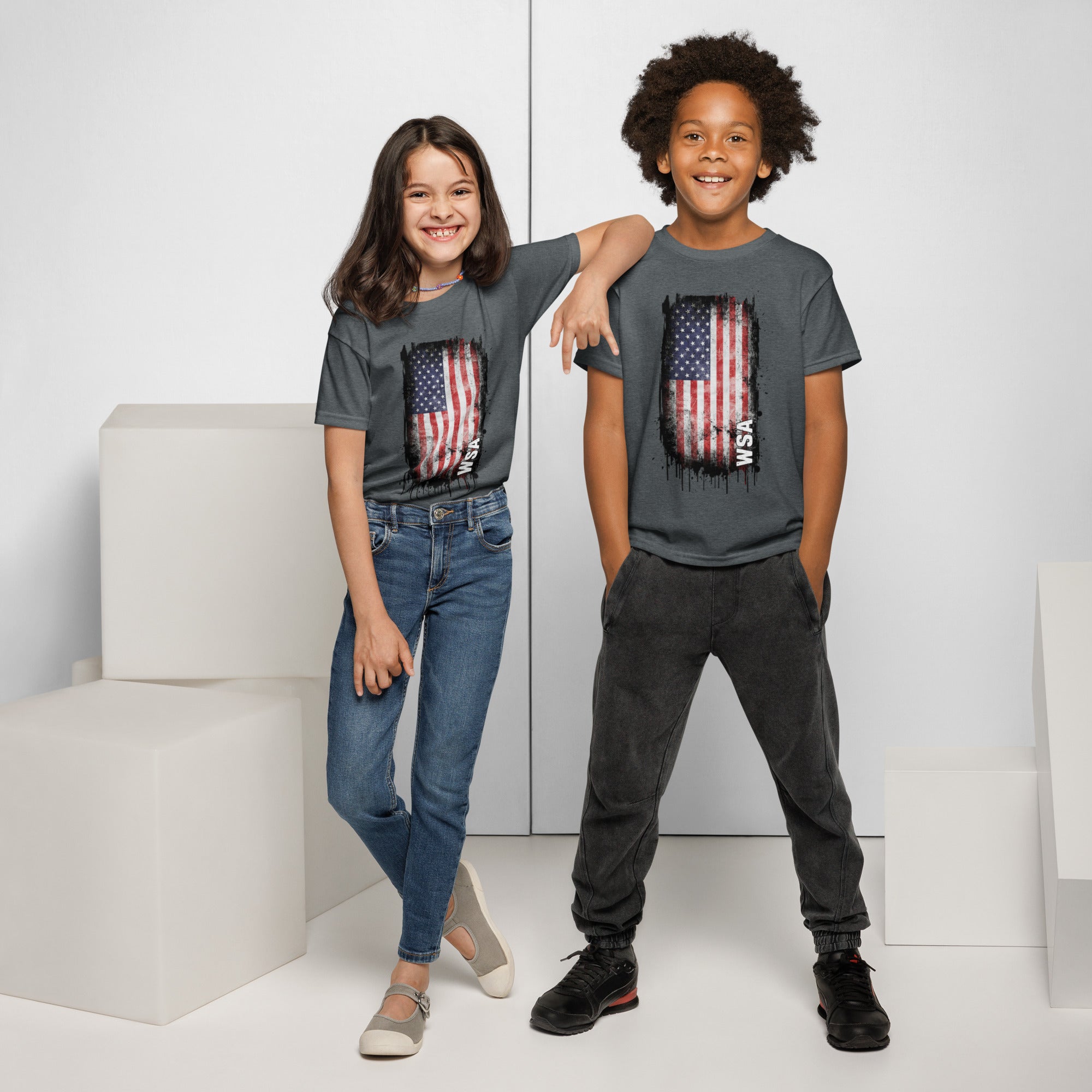 Two children wearing gray t-shirts with American flag designs on a white background