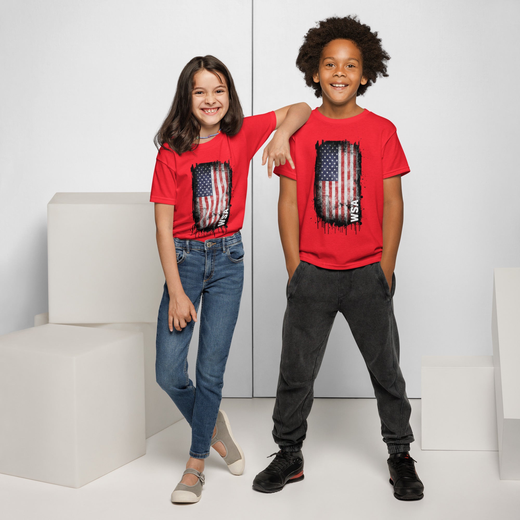 Two children wearing red t-shirts with an American flag design on a white background