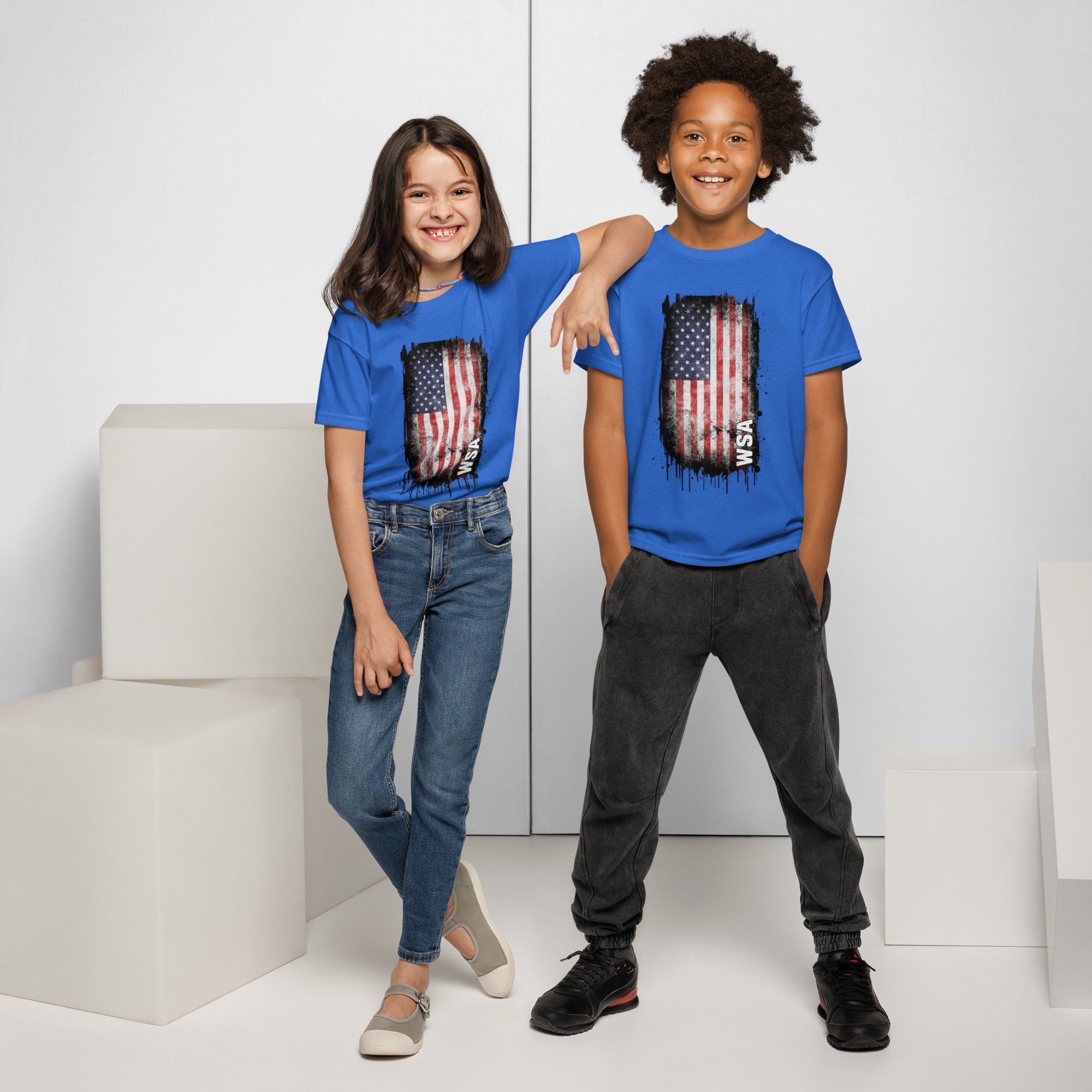 Two children wearing blue t-shirts with an American flag design, standing against a white background.